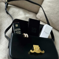 Černá dámská kabelka ilustrační foto s luxusní dekorativní kosmetikou.