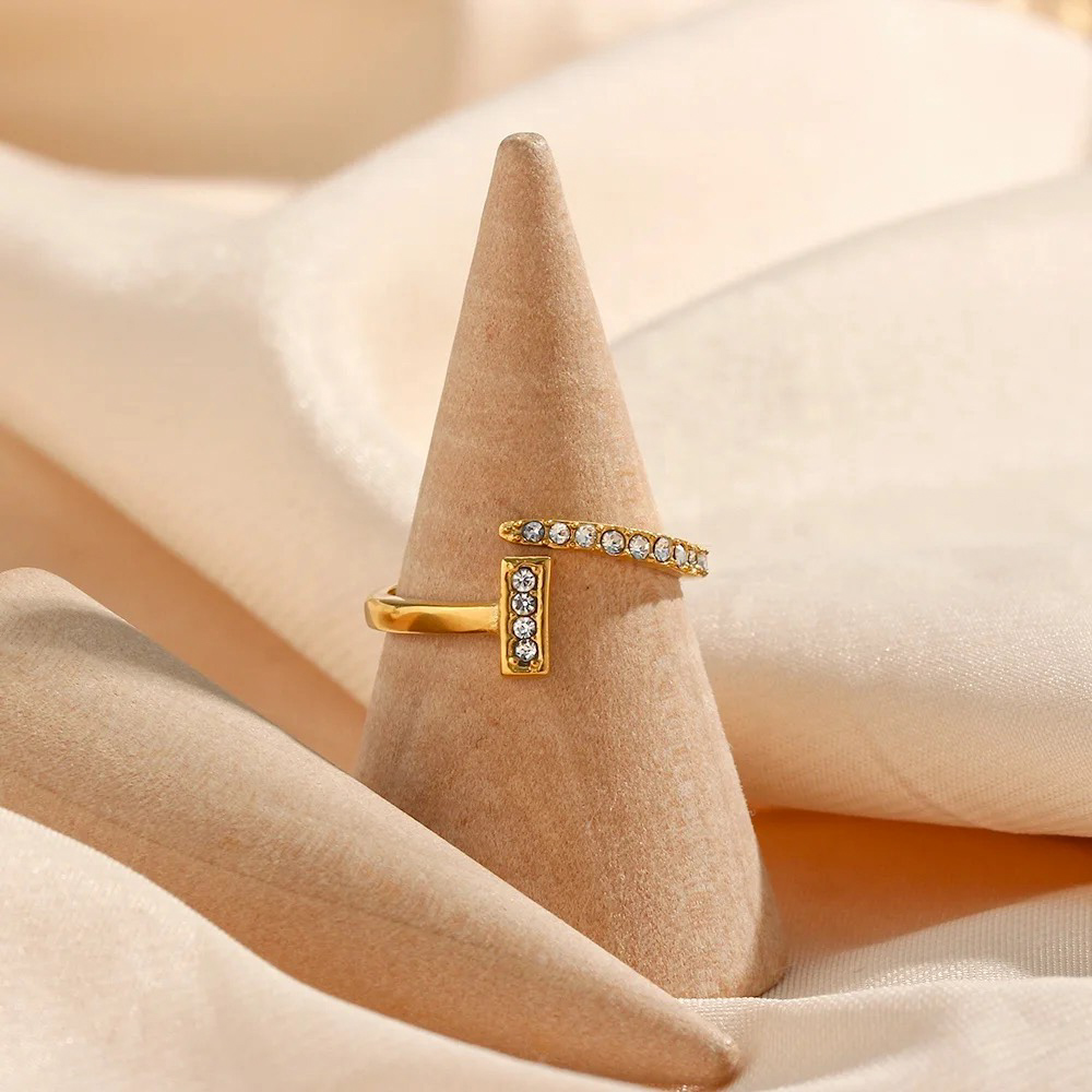 Luxusní zlatý prstýnek se zirkony, vyroben z chirurgické oceli.