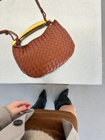 Elegantní hnědá crossbody kabelka z kvalitní vegan kůže s ručně pleteným designem a unikátním zlatým uchem. Stylový doplněk inspirovaný luxusními kabelkami, ideální pro každý den i večerní outfit.