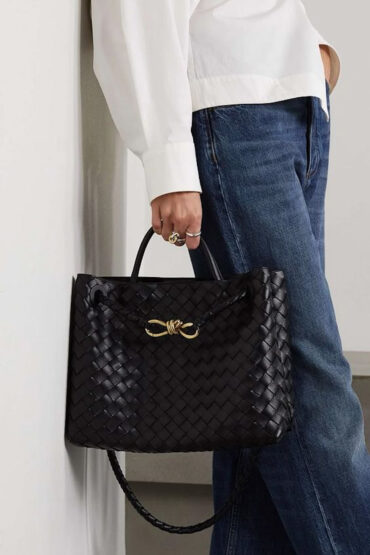 Elegantní černá tote kabelka z vegan kůže s ručně tkaným vzorem a zlatým uzlem, ideální do kanceláře i na každodenní nošení.