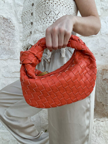 Elegantní pletené psaníčko z vegan kůže v oranžové barvě. Designer inspired kousek, který se nosí pohodlně v ruce. Ideální na večerní příležitosti i stylové denní nošení.